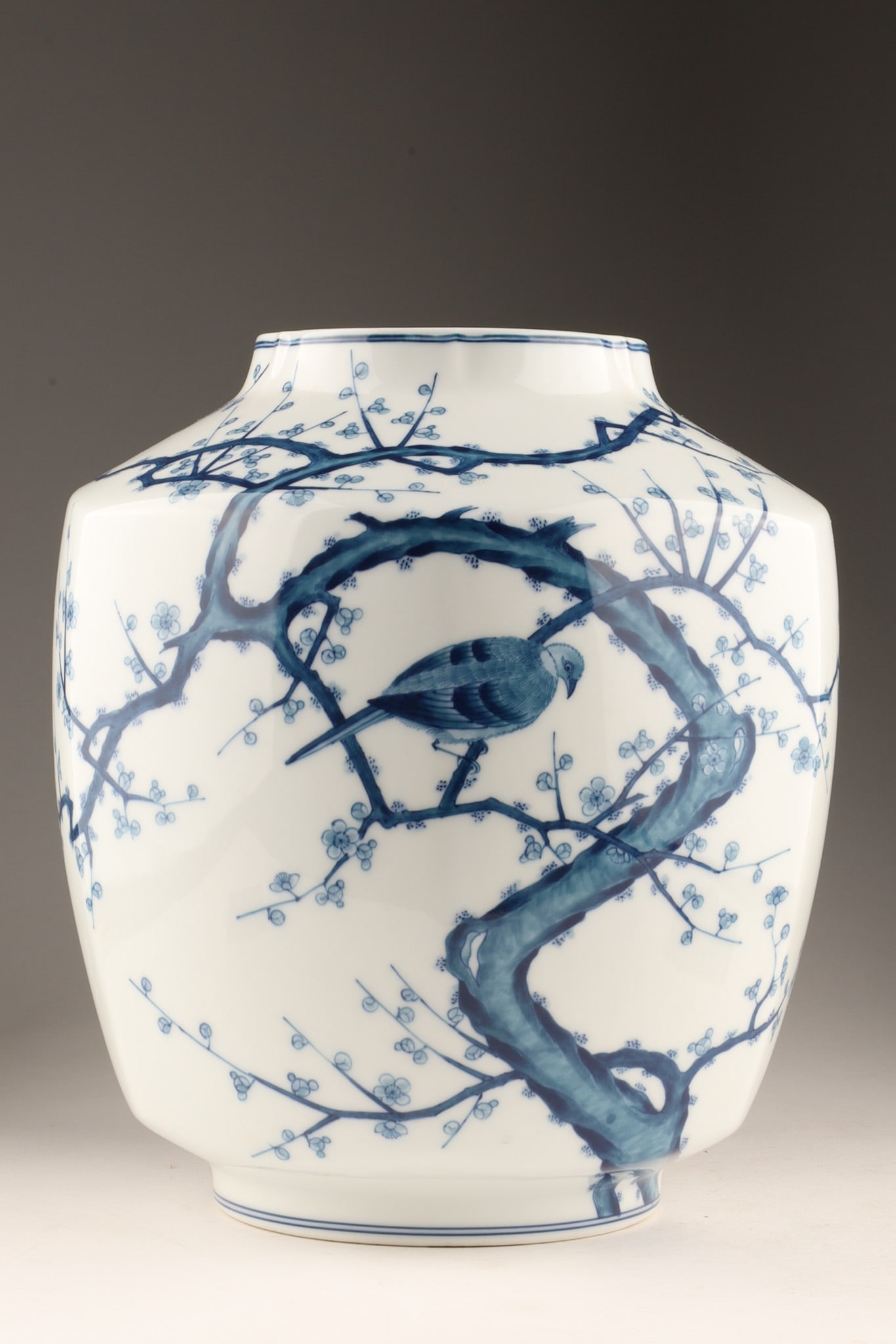 Japanese Arita Ware Blue and White Porcelain Vase: Japanese Arita ware (Arita-yaki) porcelain vase featuring a traditional hand-painted scene in underglaze cobalt blue (Sometsuke) depicting a bird perched upon a gnarled plum blossom (Ume) branch, on a
