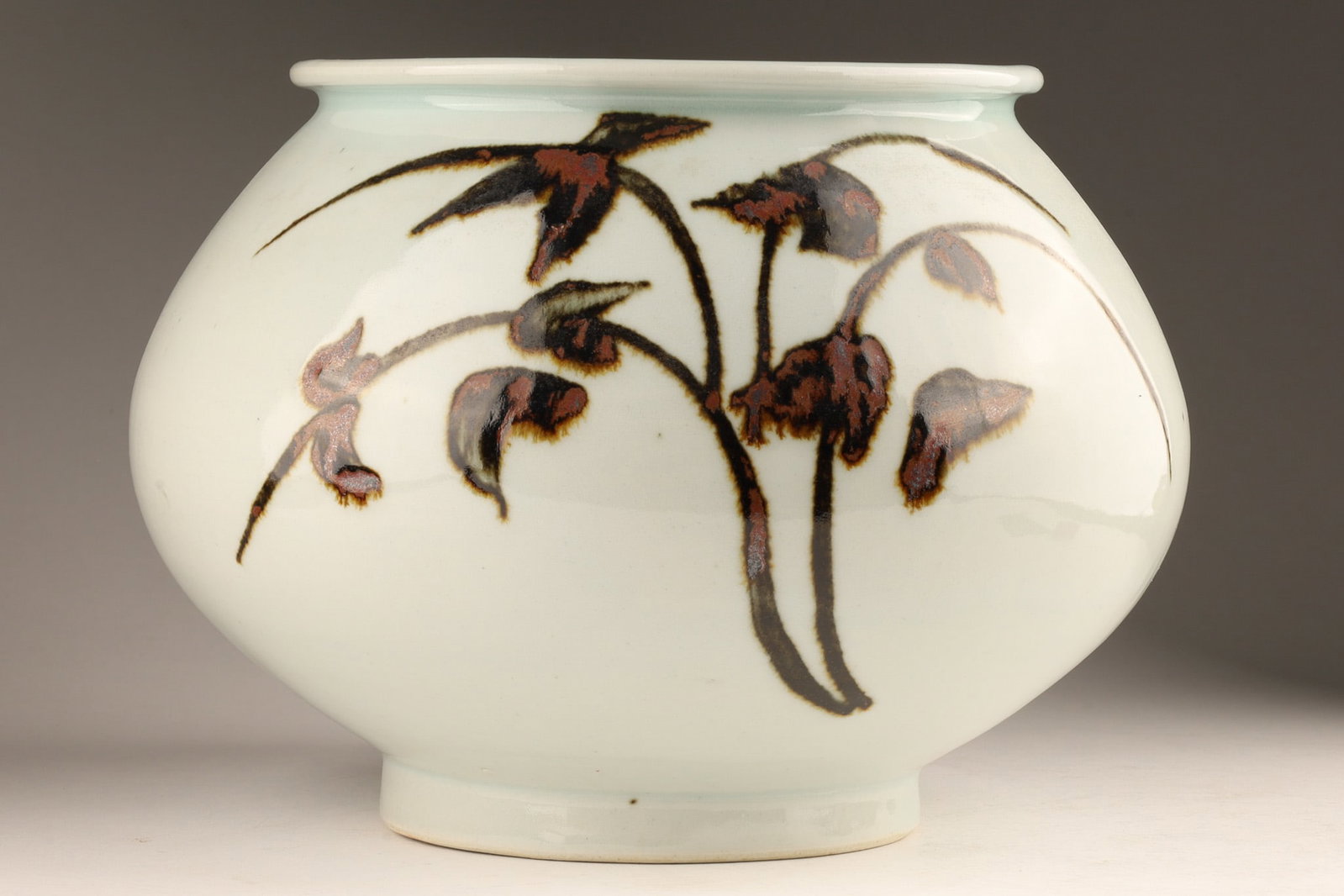 Korean Iron-Painted White Porcelain Jar by Master Ji Soon-tak (1912-1993): A mid-to-late 20th-century Korean white porcelain (baekja) ceramic jar created by renowned master potter Ji Soon-tak. The robust, globular body stands on a short tapered foot and features expressive b