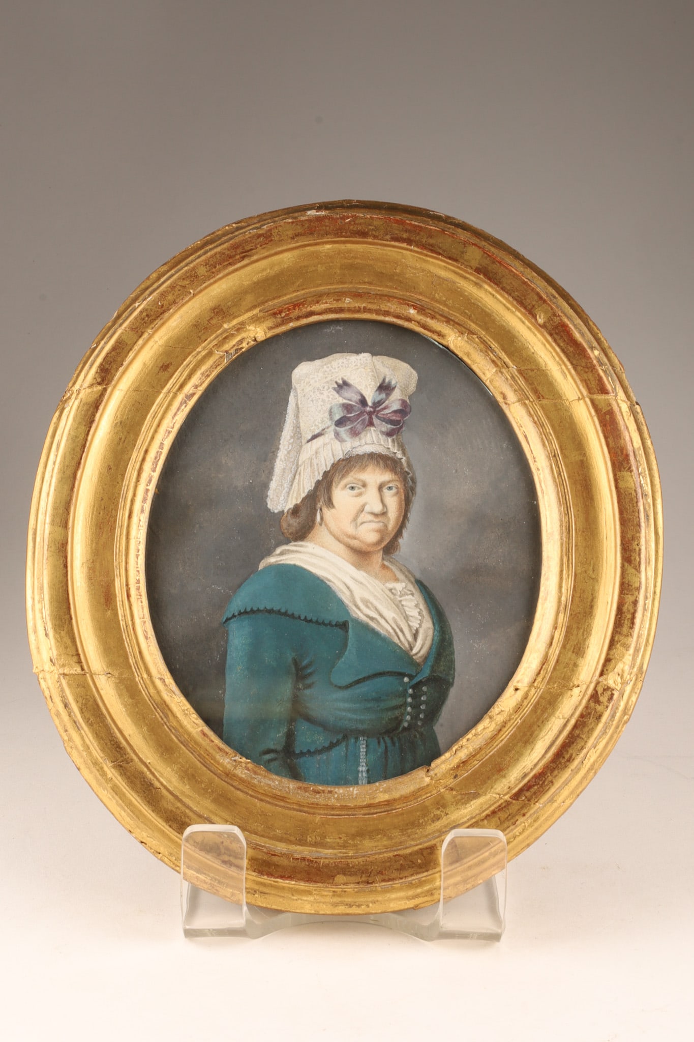 French School Pastel Portrait of a Lady, Ca. 1800 in Gilt Frame: French School, circa 1800, Portrait of a Lady in a White Bonnet Pastel on paper, oval format, depicting a lady wearing a white lace bonnet adorned with a violet ribbon, a blue Empire-style dress, and 