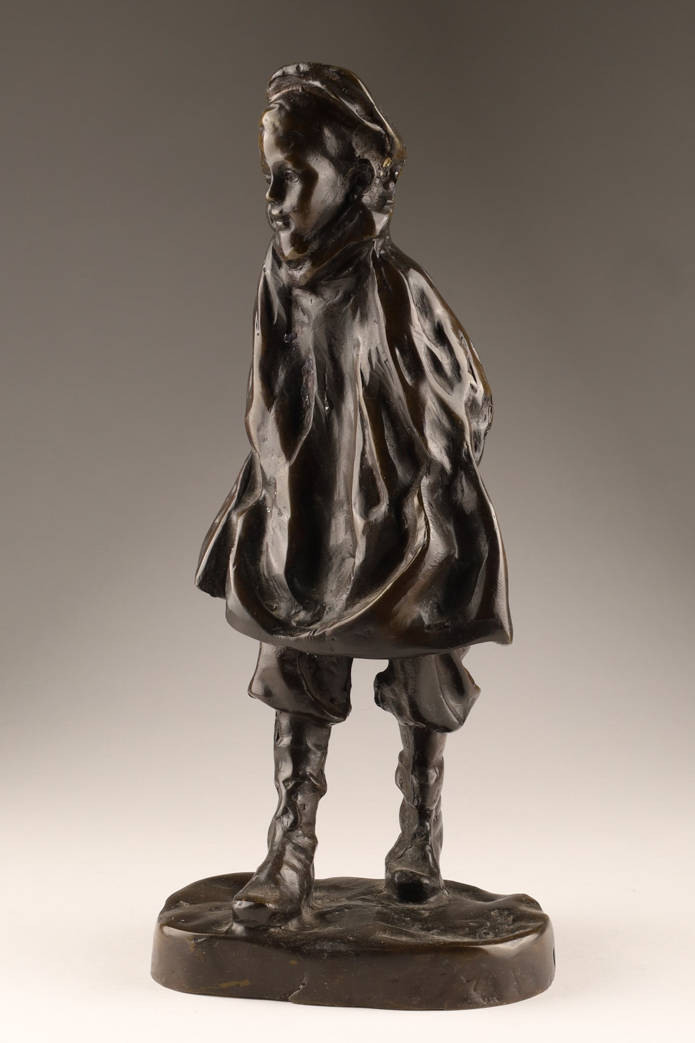 Josep Cardona i Furro (Spanish, 1878-1922) Bronze Figure The Sportsman, Unsigned: An antique patinated bronze figure titled the Sportsman, created by Spanish sculptor Josep Cardona i Furro (1878-1922). The sculpture depicts a young boy dressed in a coat and cap, standing on a natur