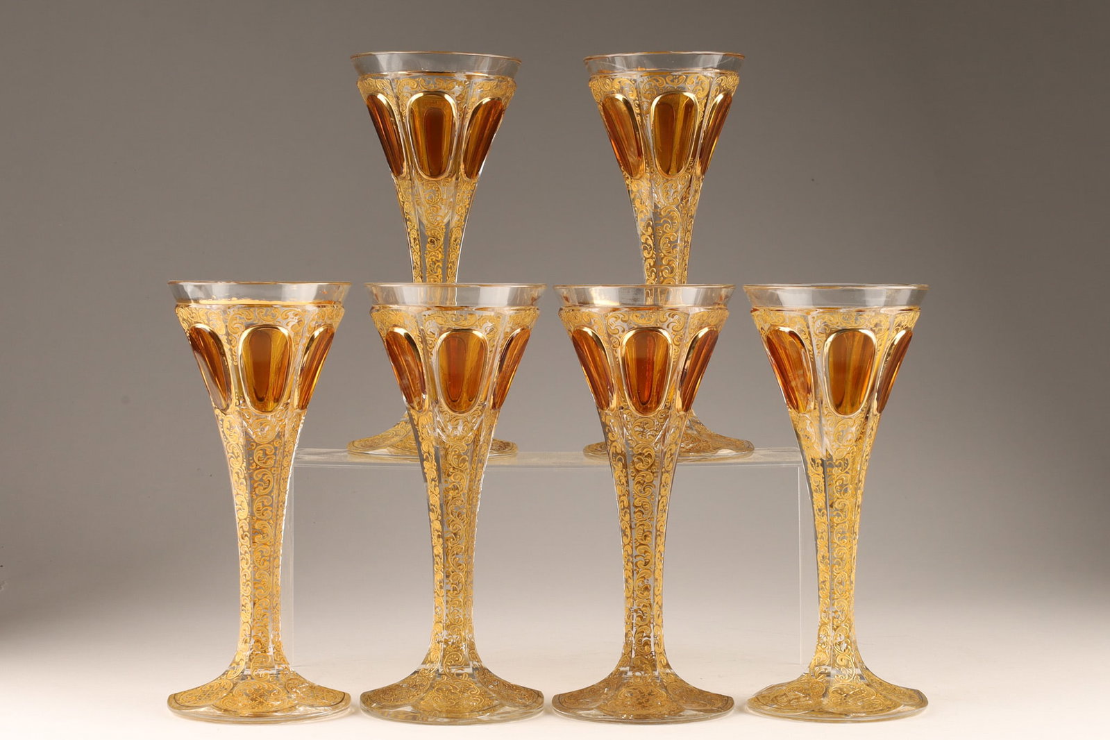 Antique Bohemian Amber and Gold Moser Attrib. Cordial Glasses: A set of 6 antique or vintage bohemian cordial glasses are attributed to Moser and feature amber-colored glass with gold decorations. Measuring 7 inches H x 3 W.