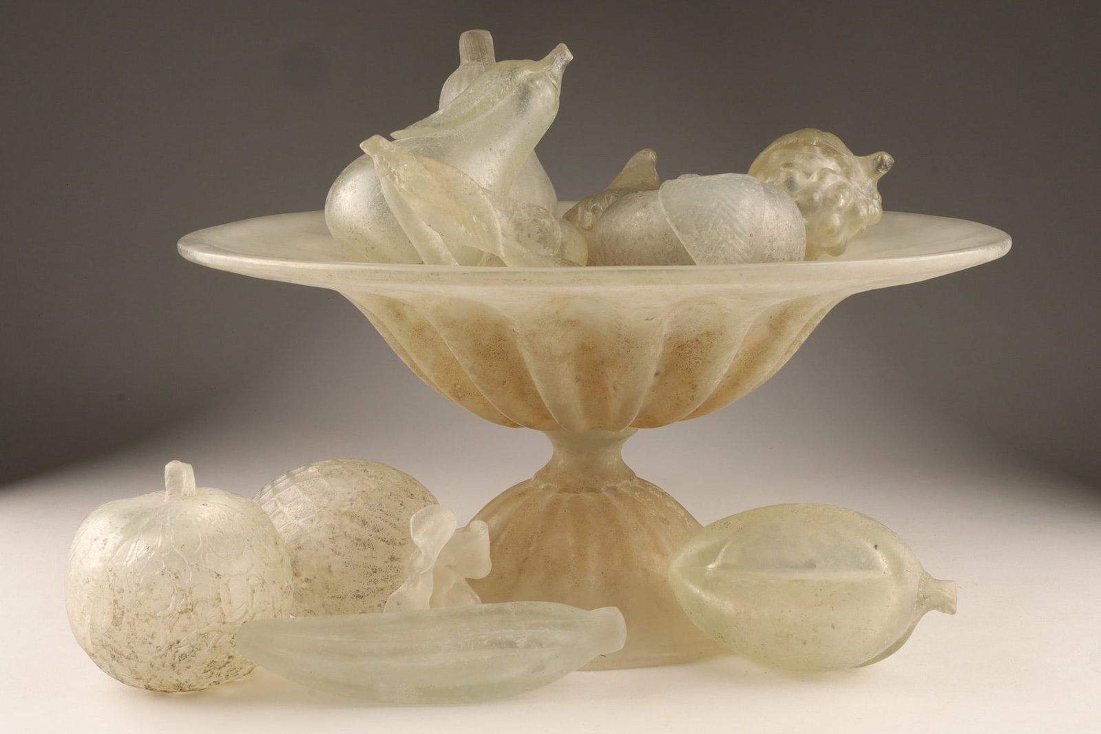 Vintage Murano Scavo Glass Centrepiece Bowl and Fruit Set: A mid-century modern Venetian art glass centrepiece set, comprising a pedestal bowl and ten (10) coordinating pieces of sculpted art glass fruit attributed to Cenedese / Barbini. Every piece is execut