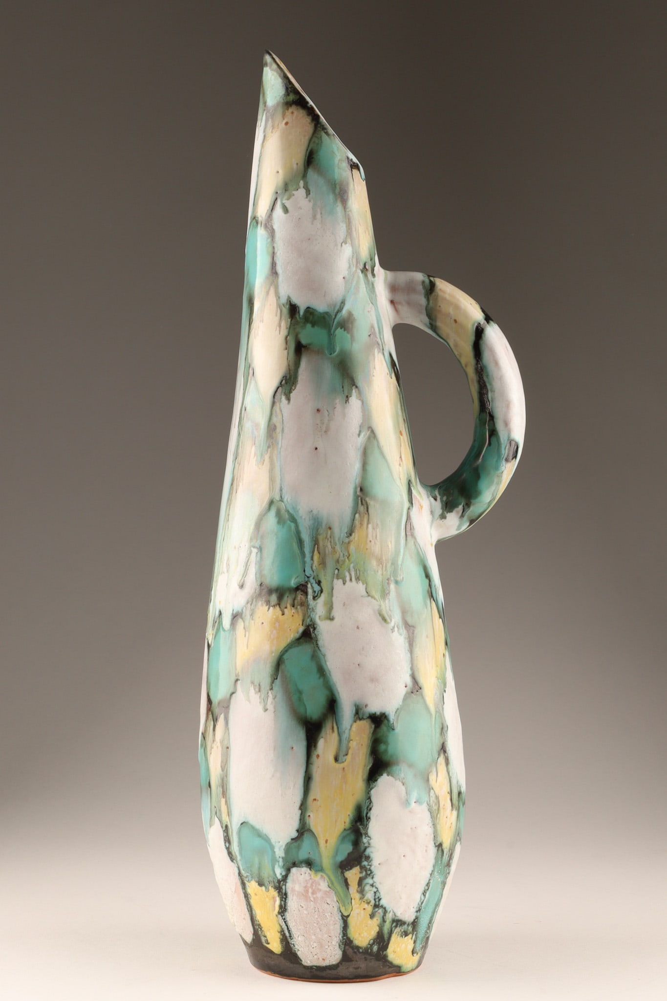 Rare MCM Signed Maurice Chalvignac Studio Pottery Jug: A rare mid-century studio art pottery pitcher/jug by Canadian ceramicist Maurice Chalvignac. Features a highly stylized, elongated asymmetrical form with a sharp pouring spout and arched handle. Decor