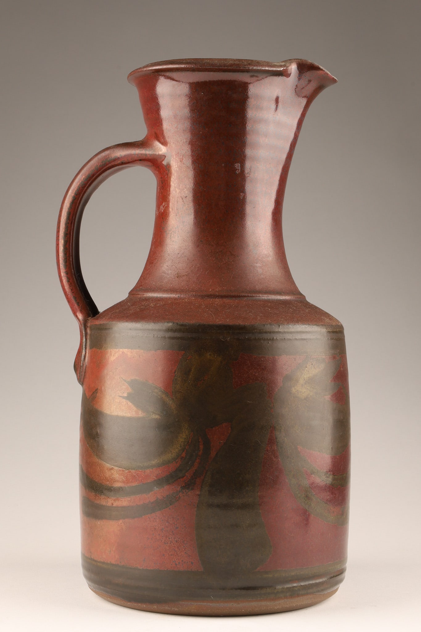Large Signed Robin Hopper (1939-2017) RCA Studio Pottery Pitcher: Robin Hopper, R.C.A. (British-Canadian, 1939-2017) Stoneware Studio Pottery Pitcher with burgundy red glaze and abstract design on the body. Marked on base and impressed mark on side. 11.5 inches H x 