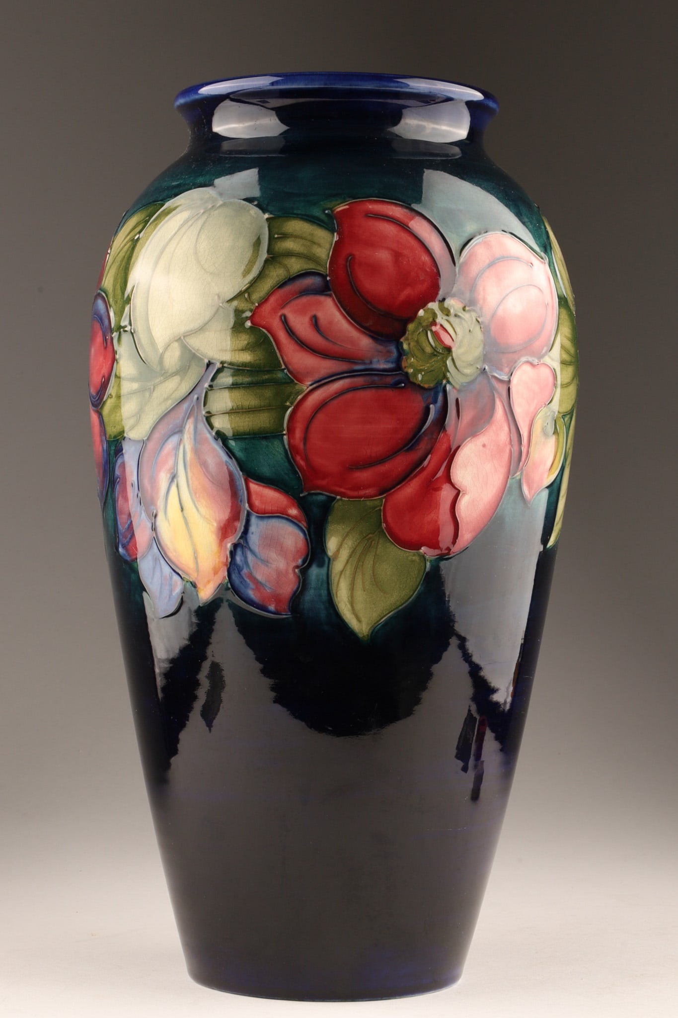Large Moorcroft Art Pottery Vase, Clematis Pattern, 12.5 inches Tall: Large Moorcroft Art Pottery Vase, Clematis Pattern, featuring tube-lined decoration of clematis flowers on a cobalt ground. Measuring 12.5 inches tall. Marked on underside in signature underglaze, imp