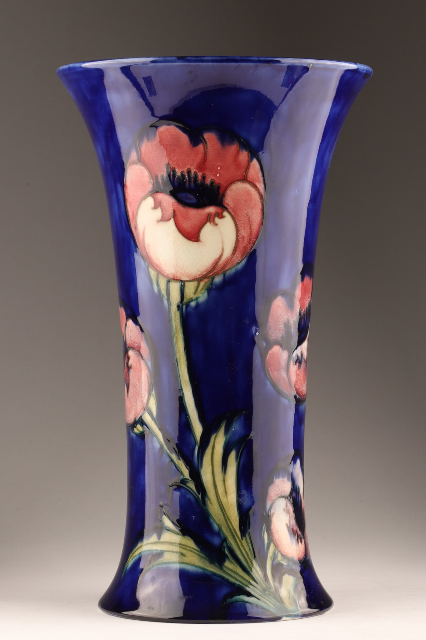 Large Moorcroft Art Pottery Vase Poppy Pattern 14 inches tall: Large Moorcroft Art Pottery Poppy Pattern trumpet vase featuring a vibrant floral pattern of tube lined poppies against a deep cobalt blue ground. 14 inches tall x 8 W. With blue underglaze painted si