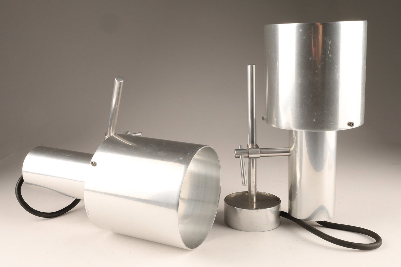 1967 Peter Nelson for Architectural Lighting MCM Aluminum Wall Sconces: A pair of 1960s Mid-Century Modern brushed aluminum wall sconces was designed by Peter Nelson for Architectural Lighting Ltd in 1967. Light cup measures 8 inches L x 4 W, adjustable post measures 7 in