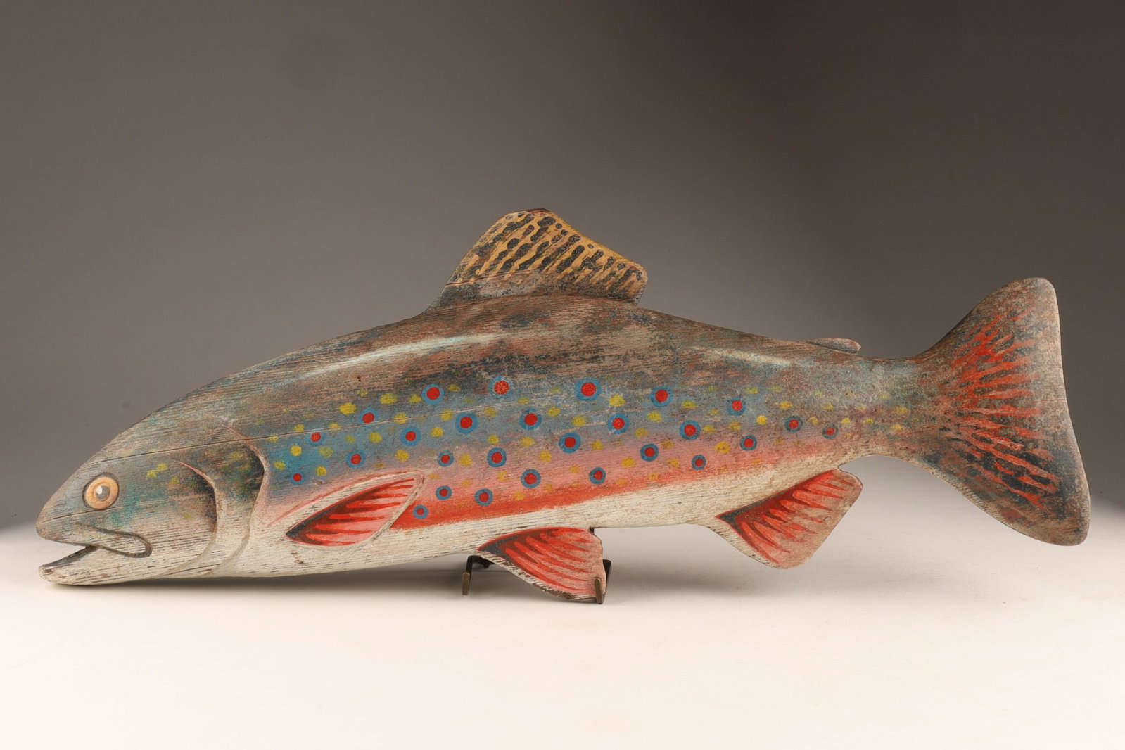 Folk Art Hand-carved and Painted Wooden Brook Trout Fish Sculpture: Features stylized, vibrant painted spots and markings of a brook trout and carved details around the mouth, gills, eyes, band wooden fins along the body. 17.5 inches L x 7 inches H.