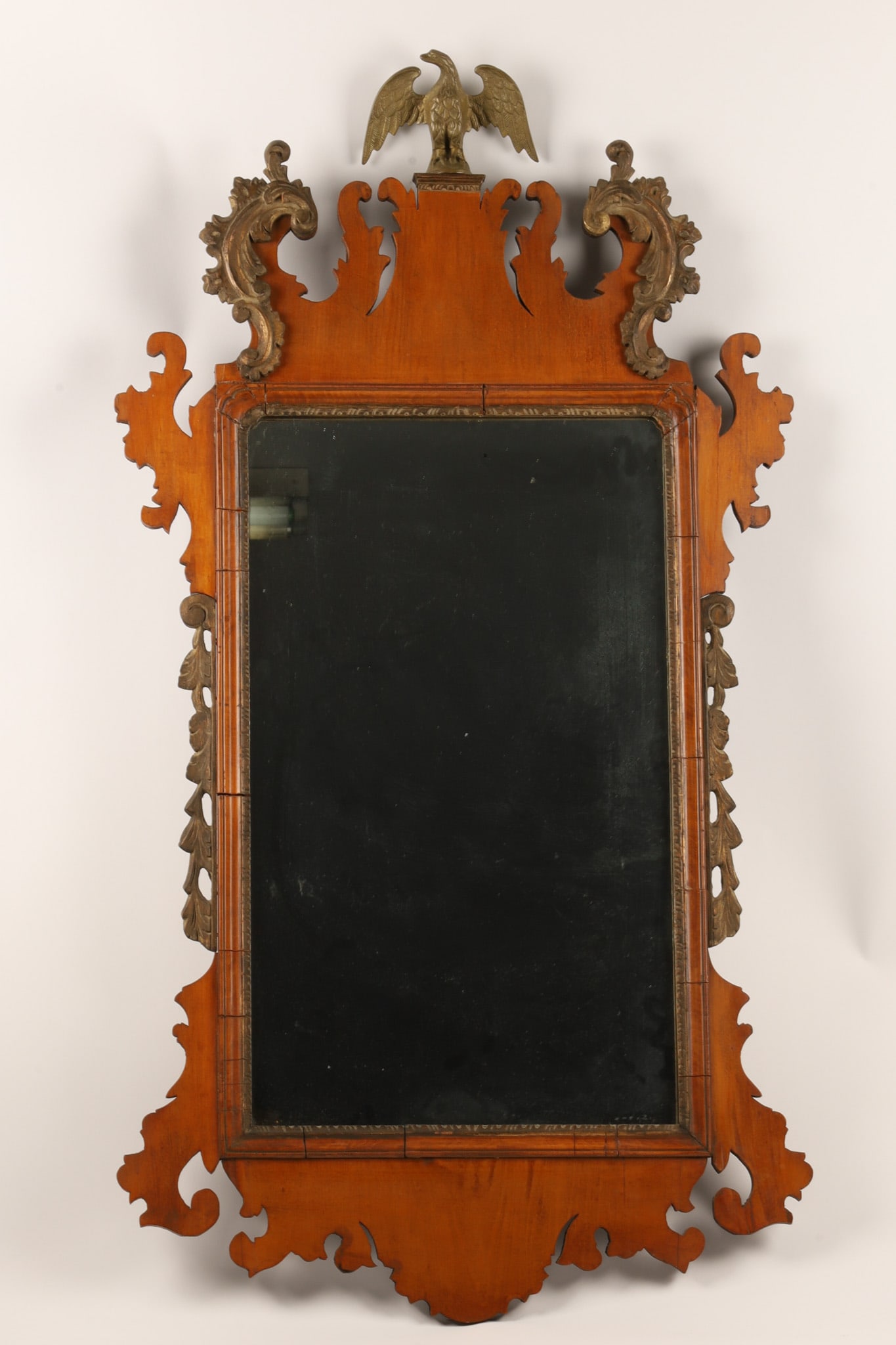 Antique 19th C. American Chippendale Parcel-gilt Mirror With Eagle: An Early American Chippendale parcel-gilt wall mirror, featuring characteristic fret-carved scrollwork along the upper cresting and lower apron, the top is crowned with a carved spread-wing American e
