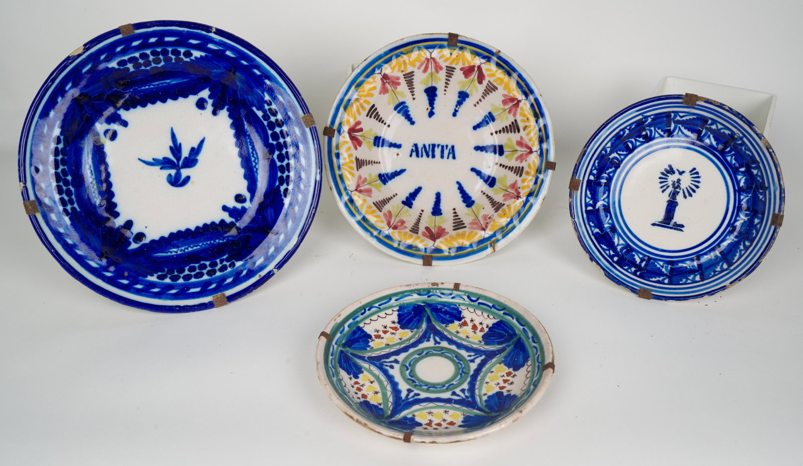 Spanish Fajalauza Talavera (Antique): Four antique plates. 11 3/4 W x 1 3/4 H in. (largest and approximate). All with old hangers. Provenance: Marietta Berman (Czech-Venezuelan artist, 1917 - 1990) acquired in Cuenca, Spain in the mid-197