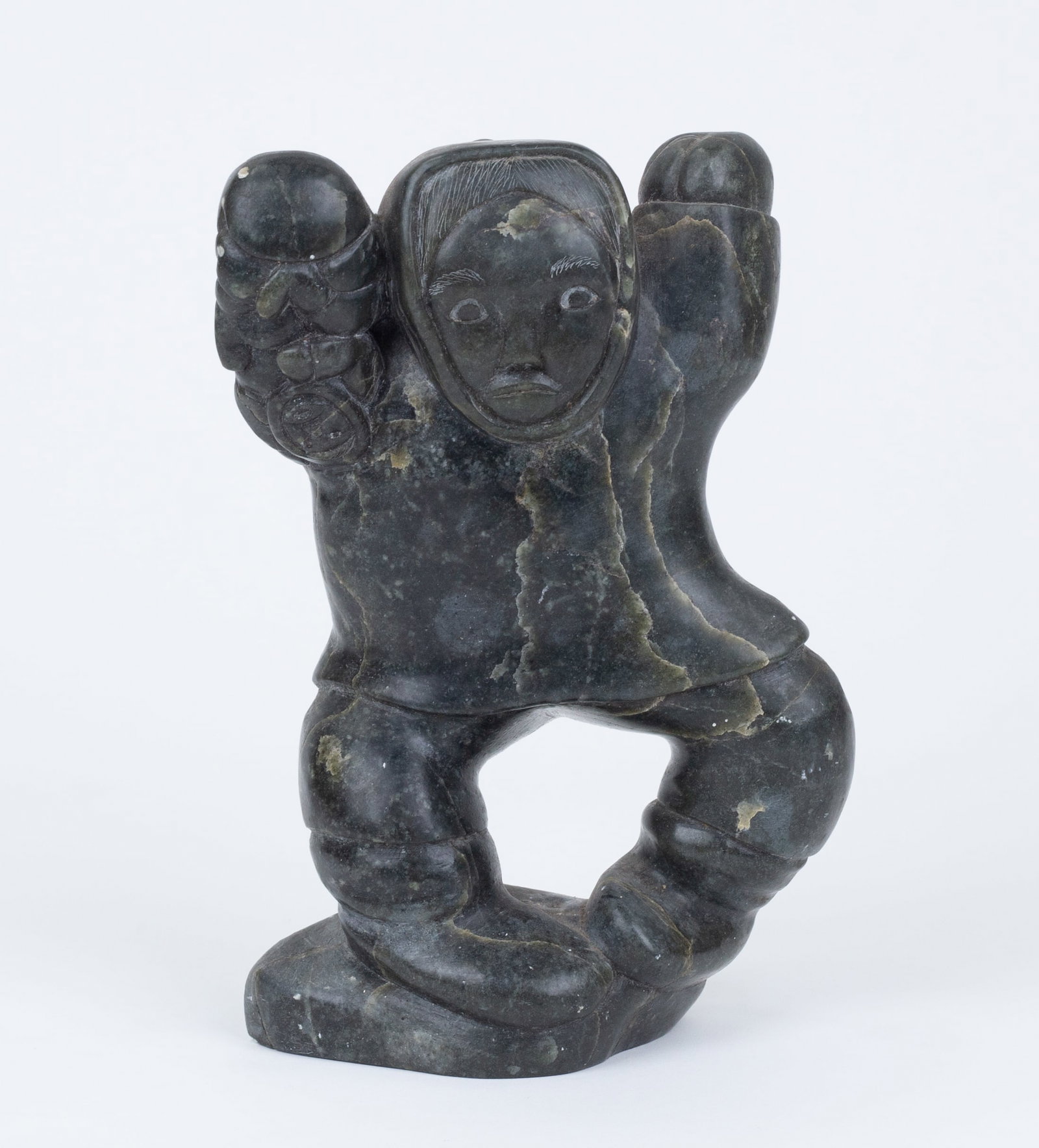 Inuit Stone Carving: 'Standing Man and Hanging Figure.' Stone. Illegible signature and numbers on base. 7 1/2 x 5 x 2 1/2".