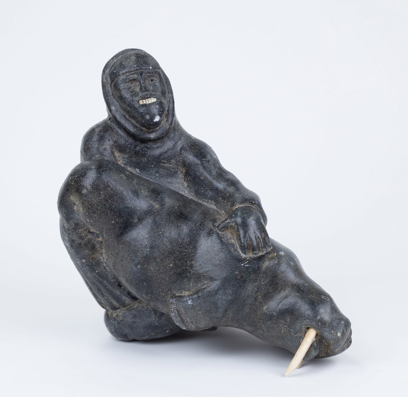 Inuit Stone Carving: 'Man and Walrus.' Stone. Illegible signature and writing on base. 9 x 9 1/2 x 7".