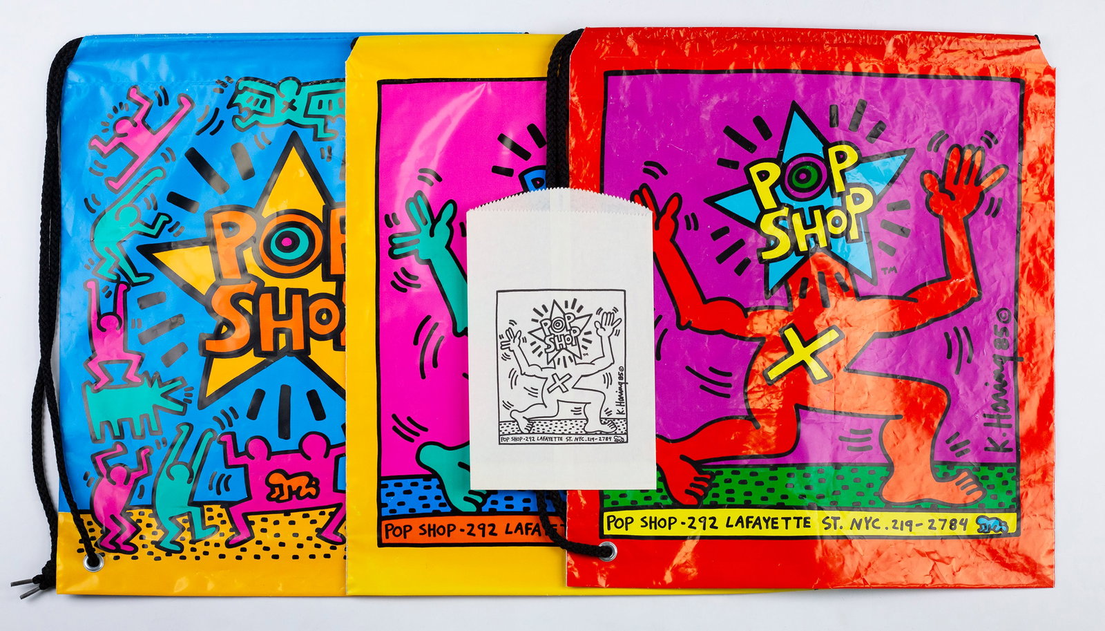 Keith Haring (American, 1958-1990): Three drawstring Pop Shop bags, and one small screen-printed paper bag. All acquired at the Pop Shop (NYC) 1980s. A single owner collection. Largest 19 x 16 3/4".