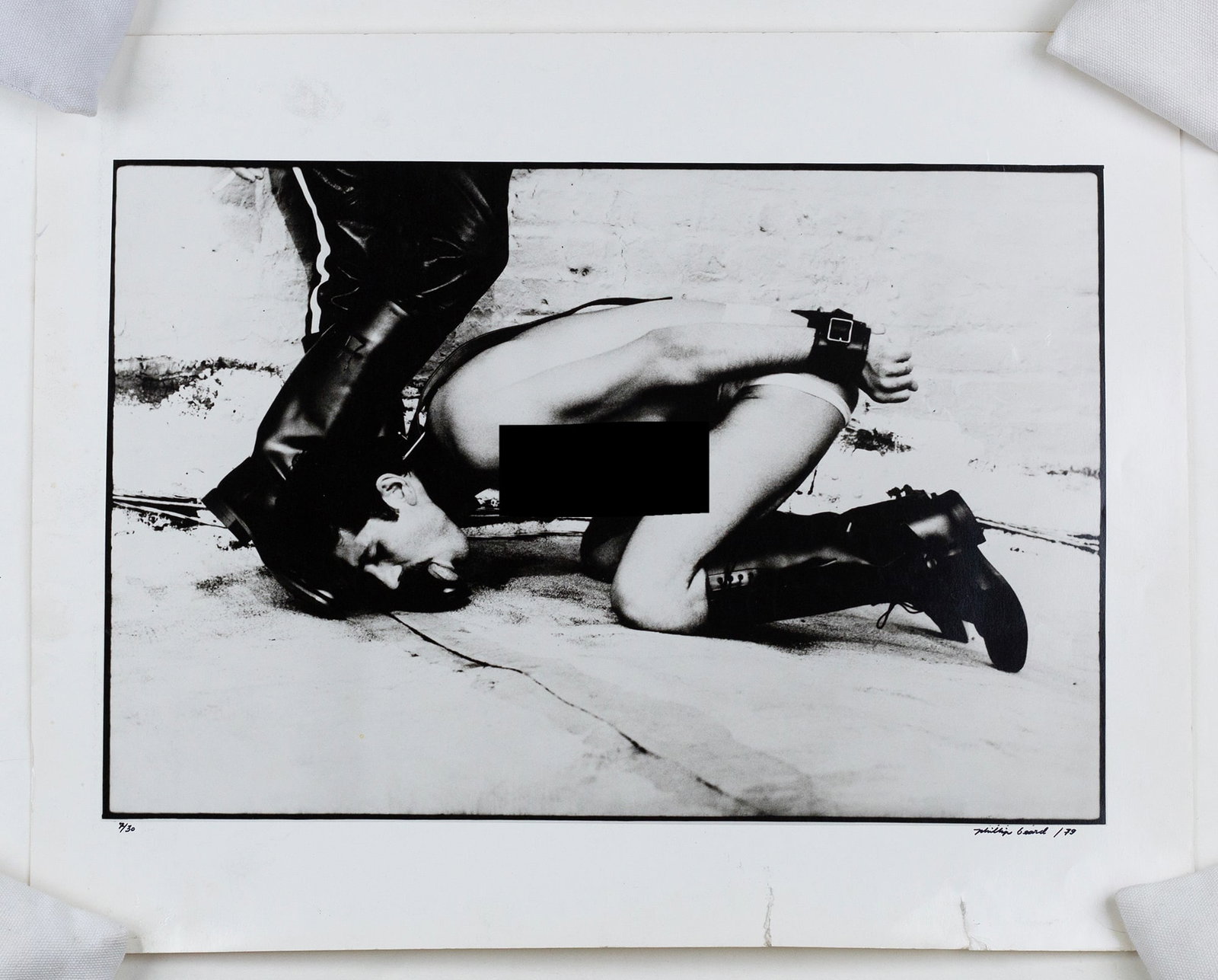 Phillip Beard (New York, 20th Century): 'Bootlicker.' Black and white photograph. 1979. Signed and dated bottom right. Numbered bottom left 7/30. 16 x 20". Image reproduced in Drummer Magazine in 1978 and in conjunction with an interview wi