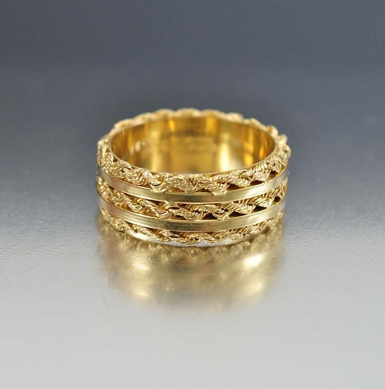 A twisted wire design covers the entire band of this ci: a twisted wire design covers the entire band of this circa 1920s art deco wedding ring. measuring 3/8 inch wide, the ring is a finger size 7.5 and hallmarked 14k, 925 for sterling silver as well as o/