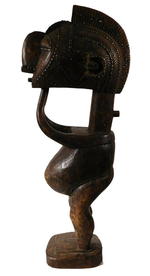 African Tribal Art Nimba (D'mba) Male Figure: Baga people, Guinea. Full figure representation of the male counterpart of the female Nimba. This is an uncommon carving of a male figure wearing af female Nimba head. Carved wood, stained black with 