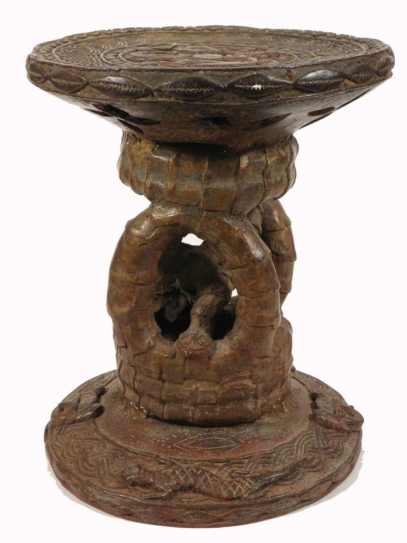 African Tribal Art Stool: Benin people, Nigeria. Lost wax casting in bronze, 20th Century. Double headed snake base, masks and other cultural objects decorate the surface. 134" H, 10.5"D. Private collection, Massachusetts very