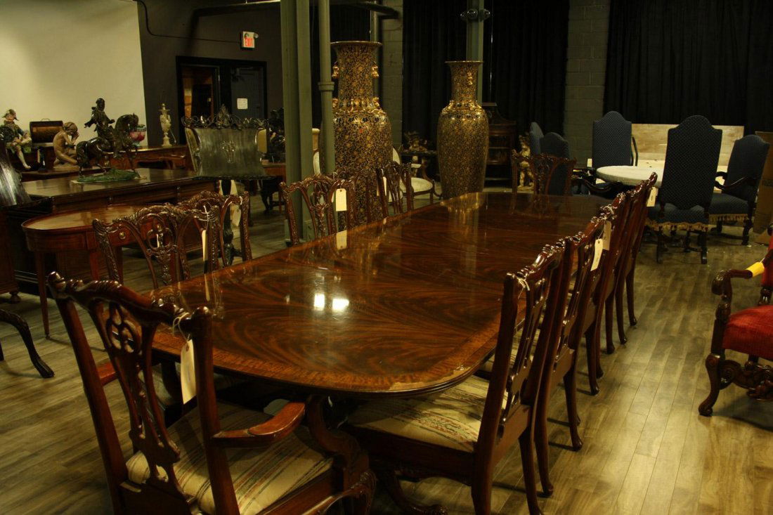 A large fruitwood dining table with satinwood inlay sta: A large fruitwood dining table with satinwood inlay standing on carved feet, with three extra leaves. Comes with twelve canvas dining room chairs.Estimate $1,000/1,500