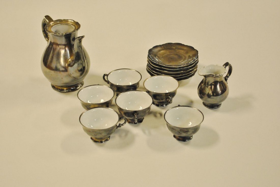 A fourteen piece metal overlay porcelain set of Bavaria: A fourteen piece metal overlay porcelain set of Bavarian origin. Estimate $120/140 Note: Small chips on some pieces.