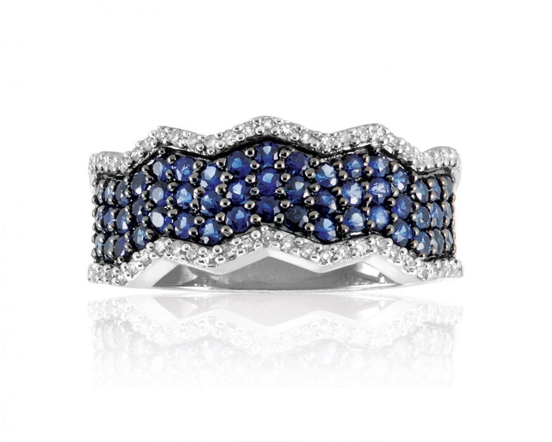 SAPPHIRE AND DIAMOND RING : SAPPHIRE AND DIAMOND RING A stylized sapphire and diamond ring, featuring small round sapphires bordered by white diamond accents. Estimate $300/500