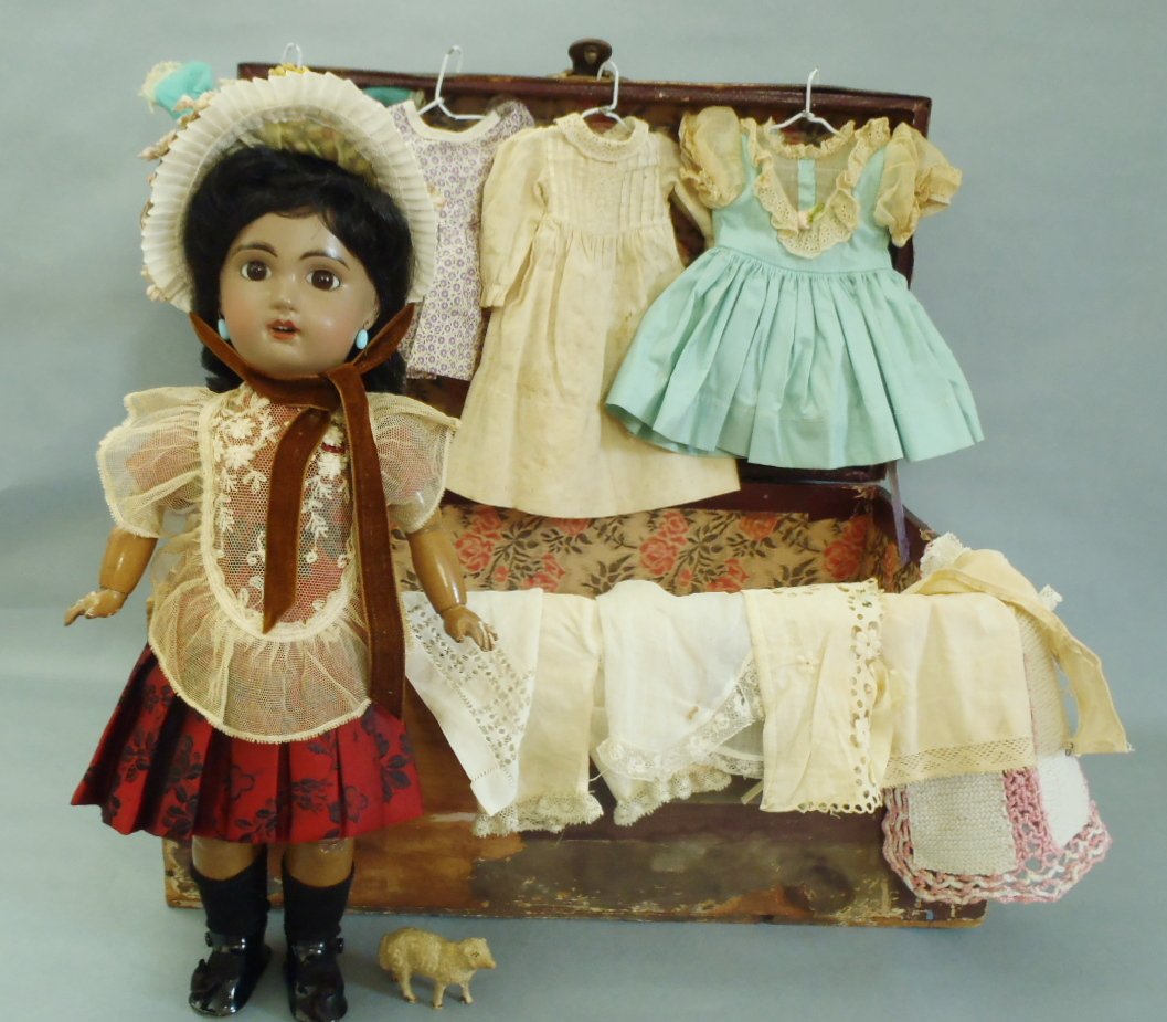 FRENCH BROWN COMPLEXIONED BISQUE BEBE JUMEAU &TROUSSEAU: FRENCH BROWN-COMPLEXIONED BISQUE BEBE BY JUMEAU WITH TROUSSEAU & STORAGE WOOD TRUNK, rare size 4, 14" tall Bisque socket head with light-brown "cafe-au-lait" complexion, dark brown glass paperweight i