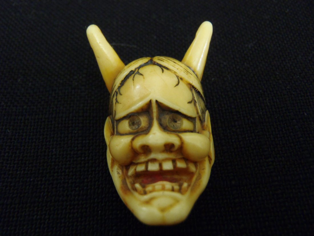 ANTIQUE CARVED IVORY NETSUKE ONI: A finely-carved Japanese netsuke mask of an Oni or devil and dating back to the Taisho-Showa periodsMeasures: 1.5” long and 0.85” long (WILL NOT SHIP TO OUTSIDE US)