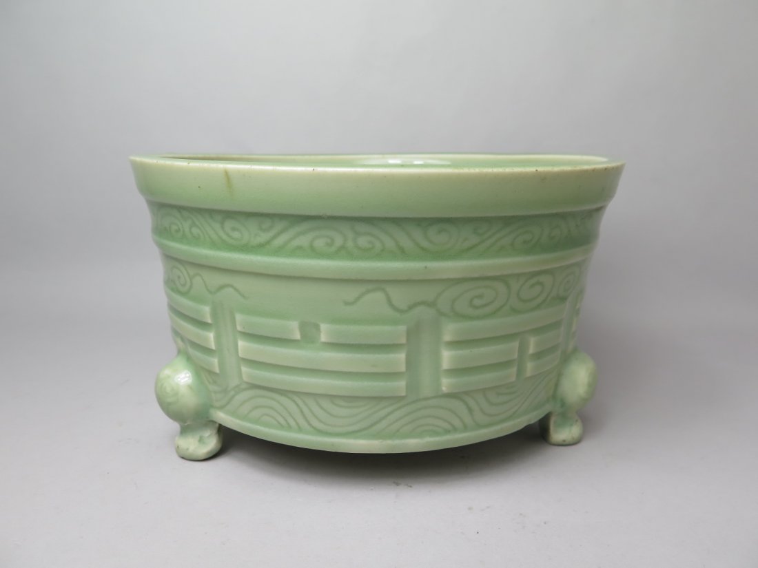 A LONGQUAN CELADON CENSER: Ming dynasty Chinese censer is sea-green tone overall. The exterior is decorated with pattern of imperial design in forms of bar lines. The base of the censer is a three legged stand. The interior of 