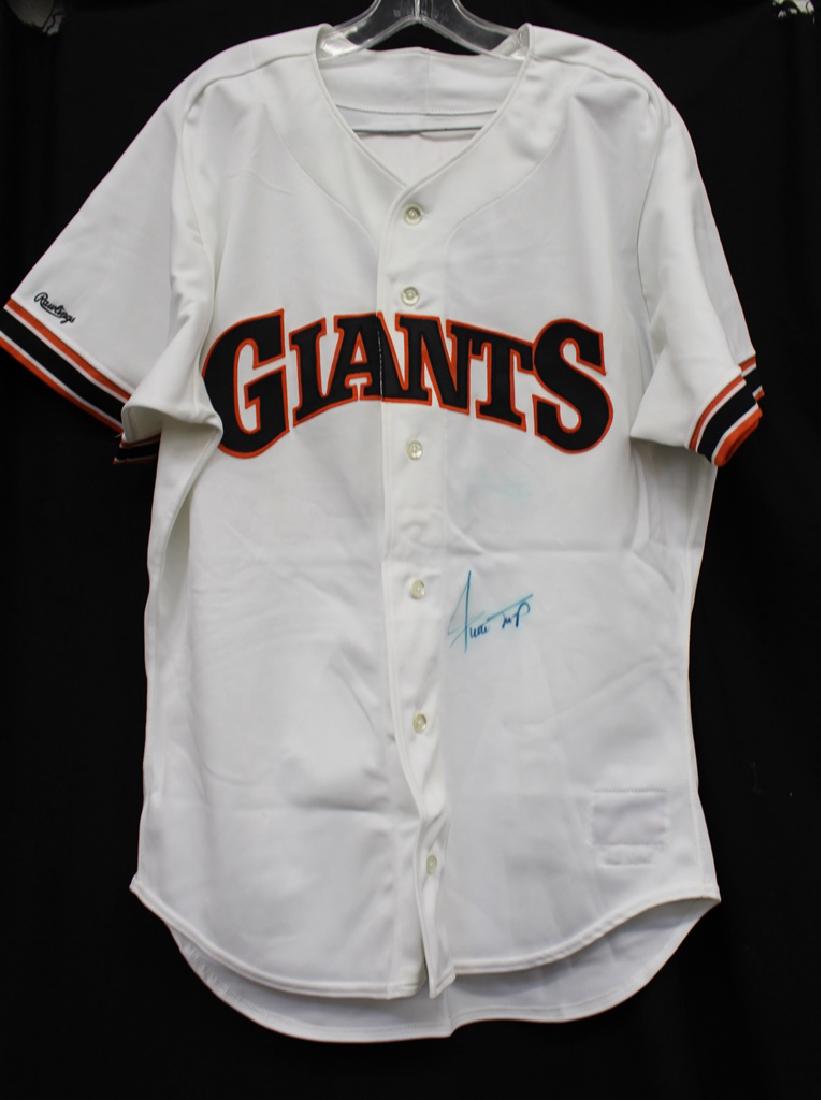 Willie Mays Autographed Rawlings Jersey JSA: Nice bold signature in blue sharpie on a size 44 Rawlings store model jersey. There is a small ghost signature from contact during storage above Willie's real signature. Still displays extremely well.