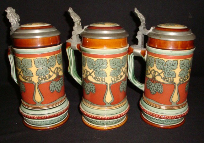 Three 1/4L Mettlach Etched Stoneware Steins: Art Nouveau decorative finish in earthtones. Impressed 2800 on bottom with Mettlach marks