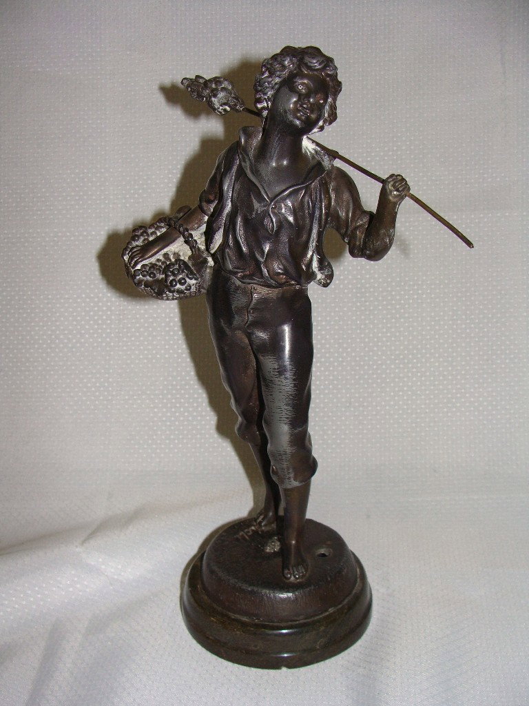 Bronze statue of boy with basket and pole: Height is 10 1/2", marked on base but unable to discern the word, it appears the boy may have been re-attached to the base on top of the makers name.