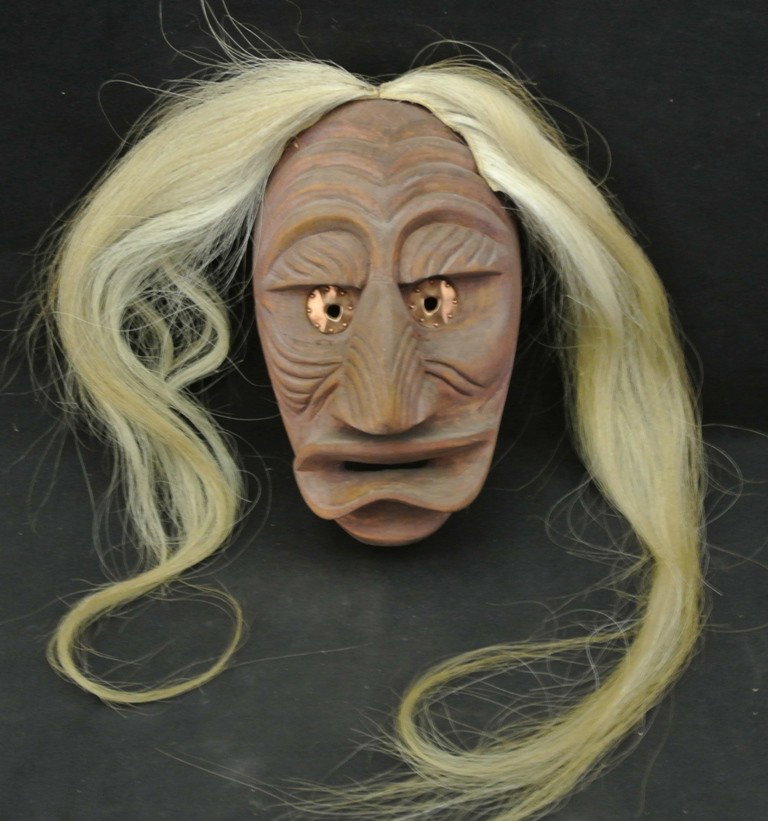 Cayuga False Face Mask by Chief Joseph Thomas: Cayuga False Face Mask by Chief Joseph Thomas. This wooden mask is identified as “Old Man Dream Mask” on the back. It has copper eyes and horsehair attached. It measures 11” long x 6” wide (no