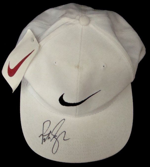 Pete Sampras Autographed Nike Cap: Pete Sampras Autographed Nike Cap; white adjustable Nike hat signed by Sampras on top of the bill; signed in black sharpie marker in beautiful script; hat still has tags; comes with an ALOA from JSA.