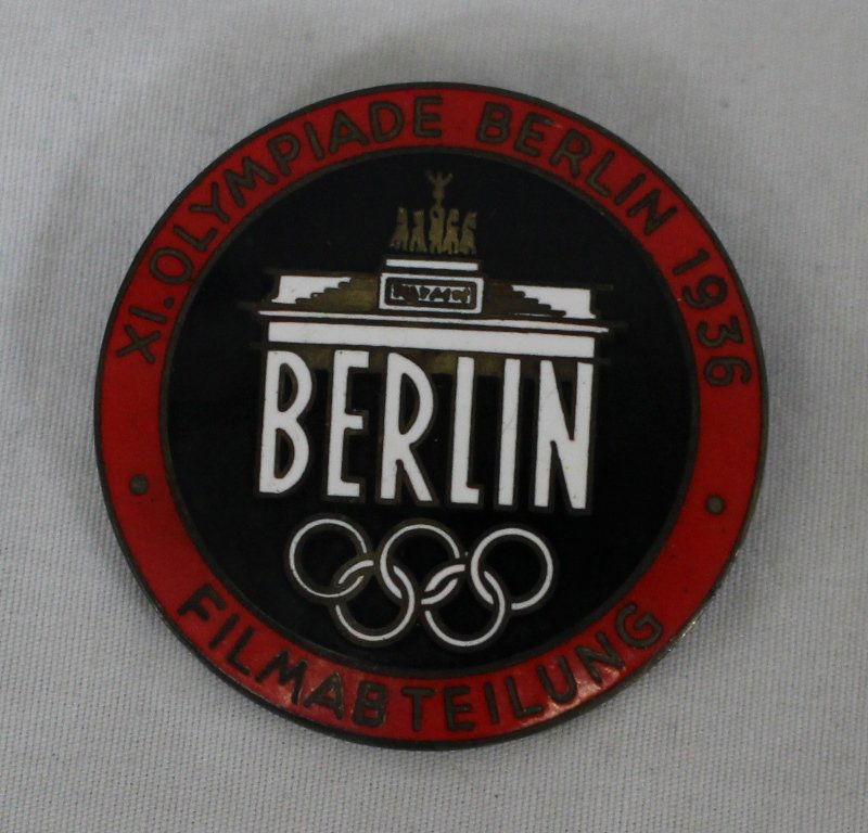 1936 Berlin Olympics Press Pin: GERMANY - BERLIN OLYMPICS 1936 A Rare XI Summer Games Filmabteilung (Film Department) red enamel lapel badge, by Rob. Neff, Berlin, pin-back, with maker's mark to reverse, 40mm; age appropriate wear.