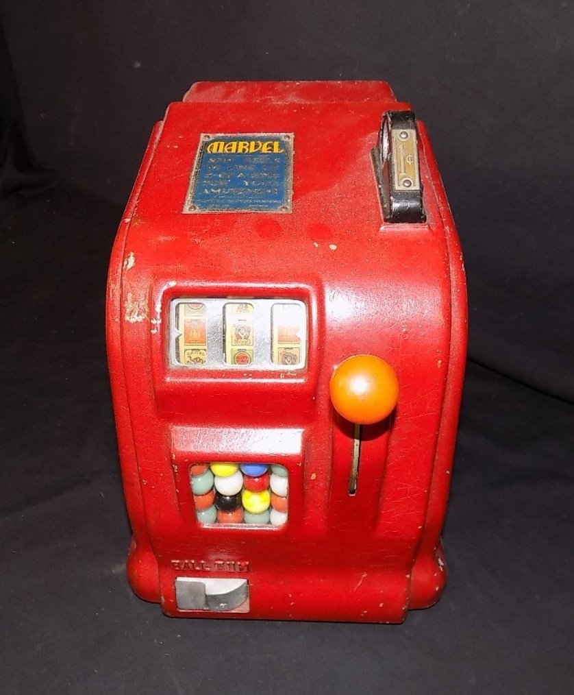 1930's Penny Marvel Cigarette Trade Stimulator: Penny machine with Camel, Lucky Stripe etc.. Wheels. Wheels spin free when coin is entered. Great side artwork painted on the sides 8"w X 11"d X 10 3/4"h with keys
