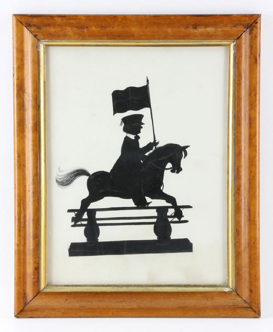 Silhouette Portrait of a Boy: Silhouette of a boy on a toy horse carrying a Union Jack flag, with gold highlights, in birdseye maple frame; 13" h x 9 7/8" w (view), 16 1/2" h x 13 1/2" w (frame). Provenance: From a Massachusetts c