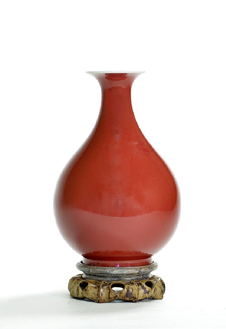 Very Fine Chinese Sang de Boeuf Yuhuchun Vase: Very fine Chinese sang-de-boeuf "Yuhuchun" vase, pear-shaped form, exterior covered in deep red glaze thinning at top rim, underglaze Qianlong seal mark to base and of the period, on original wood sta