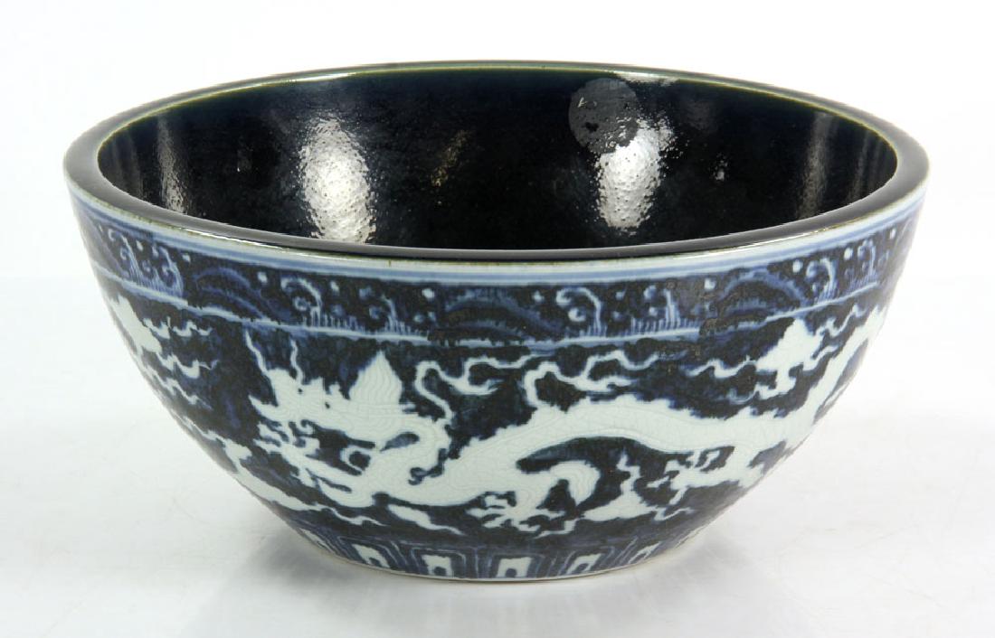 Chinese Blue and White Bowl: Chinese reverse blue and white bowl, decorated with dragon motif, with Ming Xuande mark on base, 5" h x 10 1/2" dia.