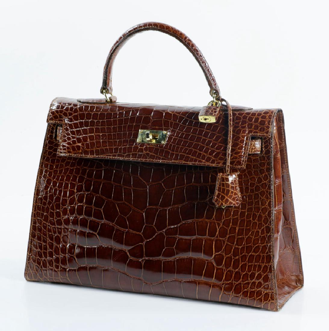 Hermes Style Kelly Sellier Crocodile Bag: Hermes-style Kelly Sellier shiny crocodile bag, 13" sq. Provenance: From a Palm Beach estate.The absence of a condition report is not an implication that the lot is in perfect condition or free from i