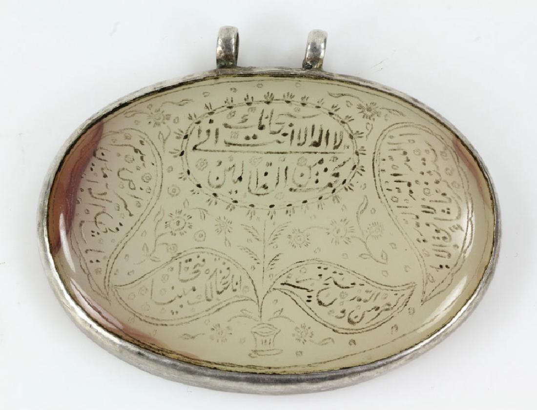 Mughal Style White Jade Pendant (Haldili): Mughal style white jade pendant (Haldili), with finely engraved inscriptions and florals, in silver frame, 2" h x 2 5/8" w. Provenance: From a Houston, Texas collection.