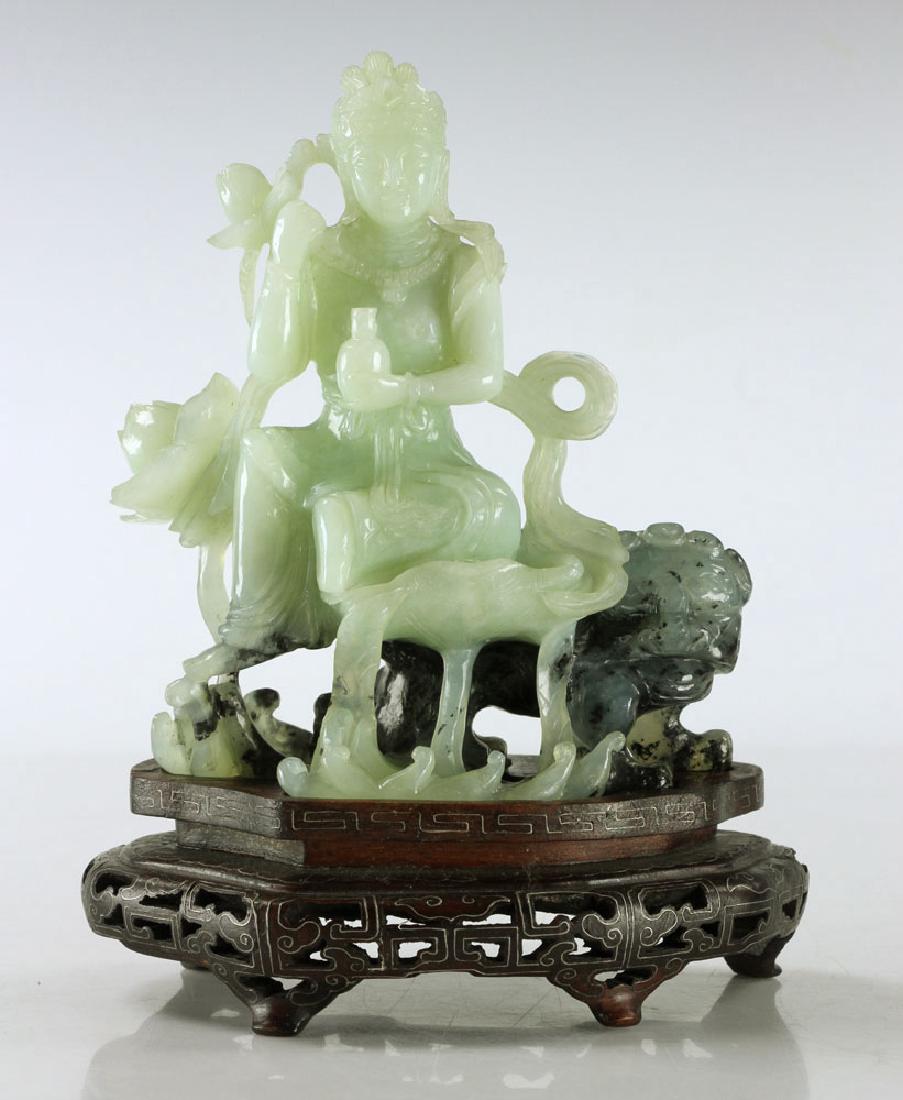 Carved Jade Seated Woman: Figure of a seated woman, carved jade, with foo dog on footed wooden base with silver inlay, 5 7/8" high x 5" wide (figure only), 7 1/2" high (overall). Provenance: from a Massachusetts estate.