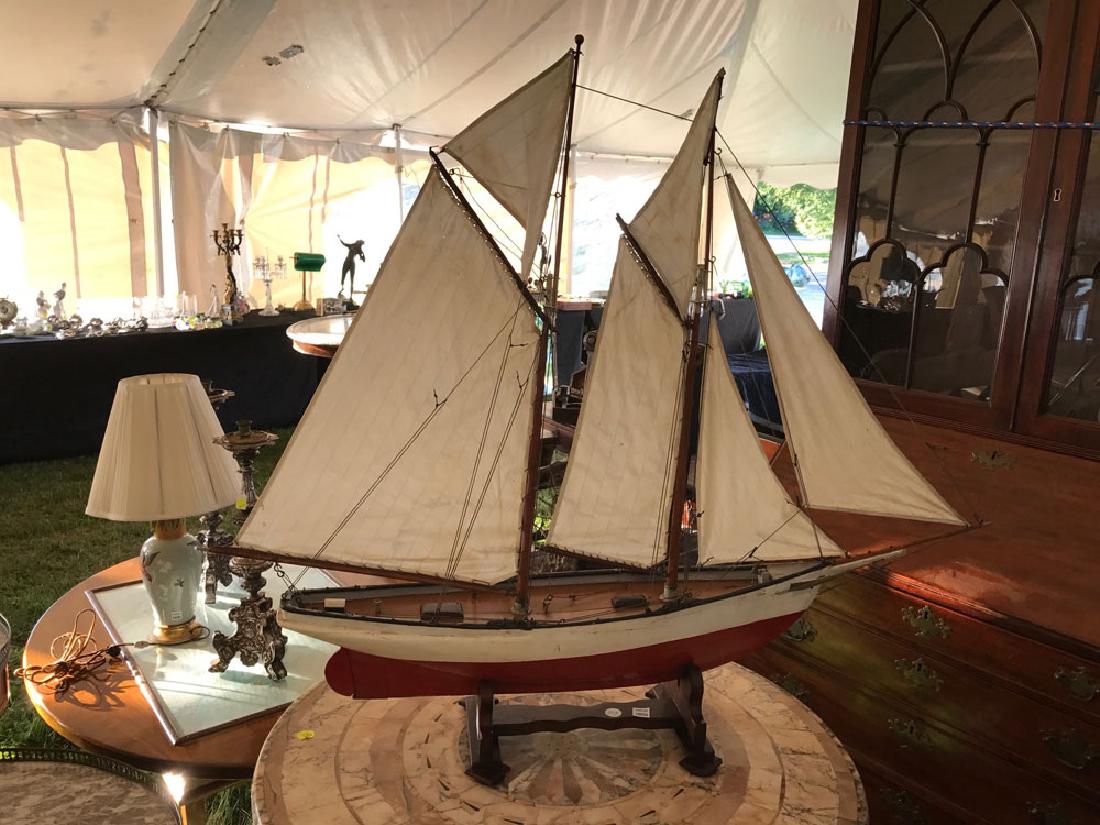 Vintage Two Masted Schooner Model: Vintage model of a two-masted schooner, with red and white hull and cotton sails.