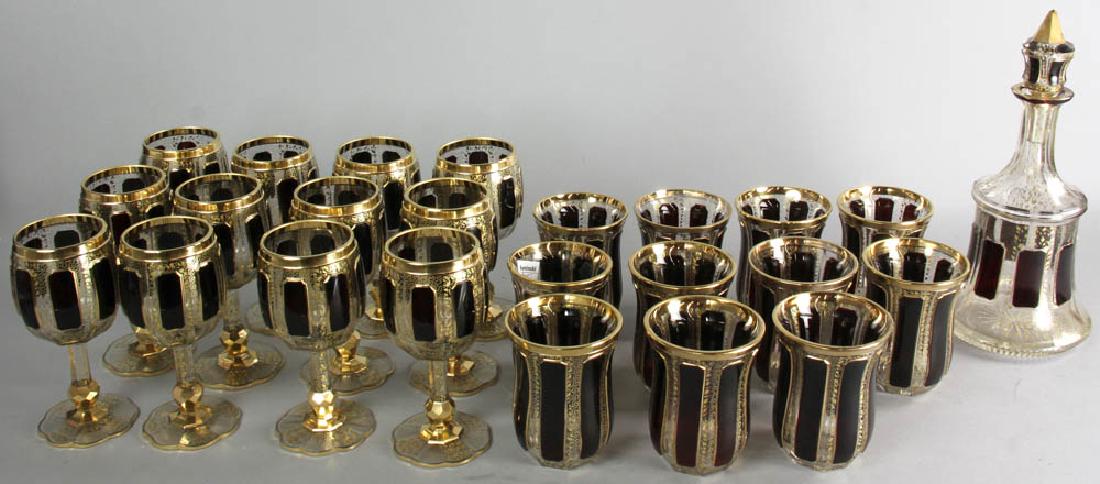 Set of Bohemian Gilt Decorated Glassware: Set of Bohemian glassware to include: decanter, 11 3/4" H; (11) goblets, 4 1/2" H; (12) footed wine glasses, 6 1/2" H. All with gilt and raised cabochon decoration. Provenance: Myrtle Beach, South Car