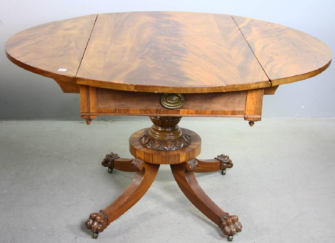 Classical Empire Mahogany Drop Leaf Table: Classical Empire flame mahogany drop-leaf table with carved pineapple post and claw feet, 28 1/2" H x 44 1/4" W x 26" D (closed), drop leaves 12 1/2". Provenance: Estate of Joan Potter, Martha's Viney