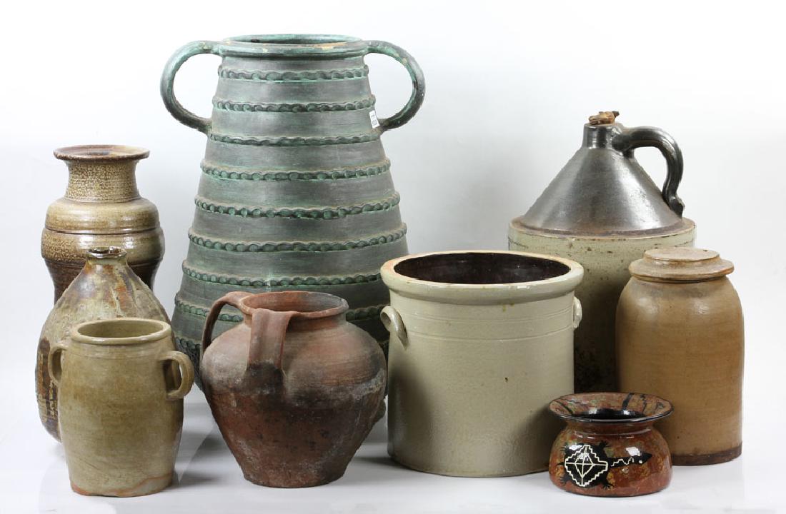Lot of Stoneware Jugs and Pots: Lot of nine stoneware jugs and pots, to include: Norton, VT decorated with blue leaf, Native American spittoon, tall European handled vessel (24" h) and six other assorted jugs.