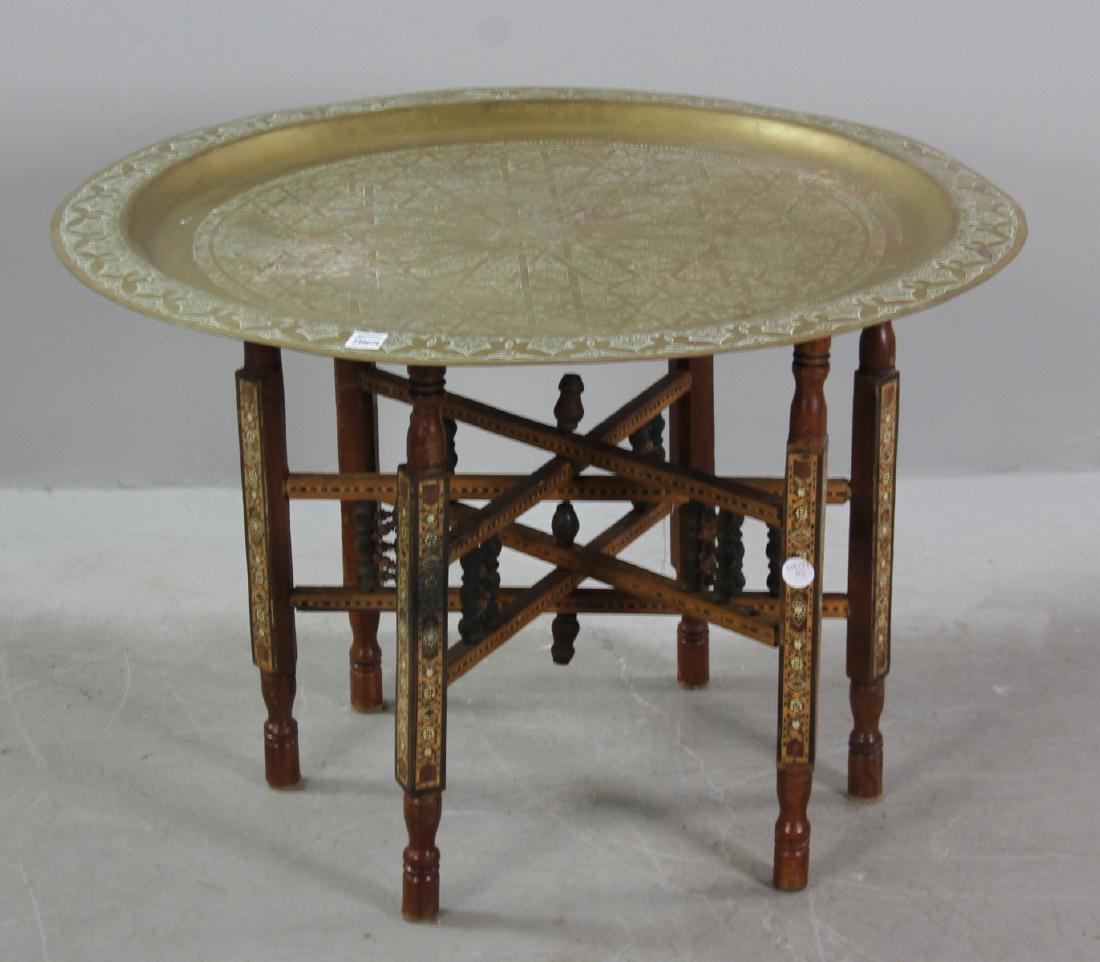 Anglo-Indian Hammered Brass Tray Table: Anglo-Indian hammered brass tray on carved and inlaid stand, 21" H x 31" diameter. Provenance: West Palm Beach, Florida collection.