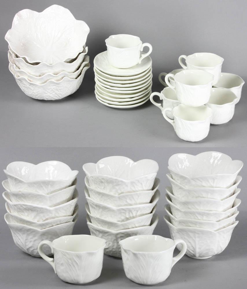 Cabbage Leaf Form Dessert Set: Earthenware dessert set, molded cabbage leaf design in white, four (4) large bowls, sixteen (16) dessert bowls, and ten (10) cups and saucers, unmarked, thirty (30) pieces total, large bowls measure 3