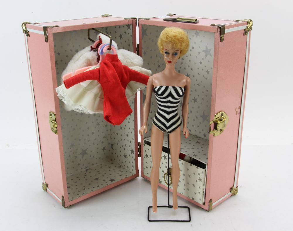1961 Barbie Doll in Original Box with Accessories: Original 1961 Barbie doll with pedestal, blonde "Bubble Cut" hairstyle in original box, along with case of clothing and other accessories. Provenance: From the estate of James Herbert, owner and opera
