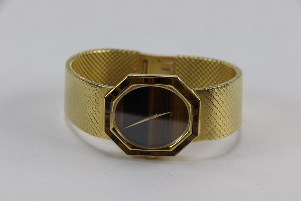 Piaget Tiger's Eye 18k Yellow Gold Wristwatch: Piaget tiger's eye and 18k yellow gold wristwatch, 6" L, approximately 55 grams TW (including movement). Provenance: From a California collector. PLEASE NOTE: payment for silver, gold, jewelry, and co