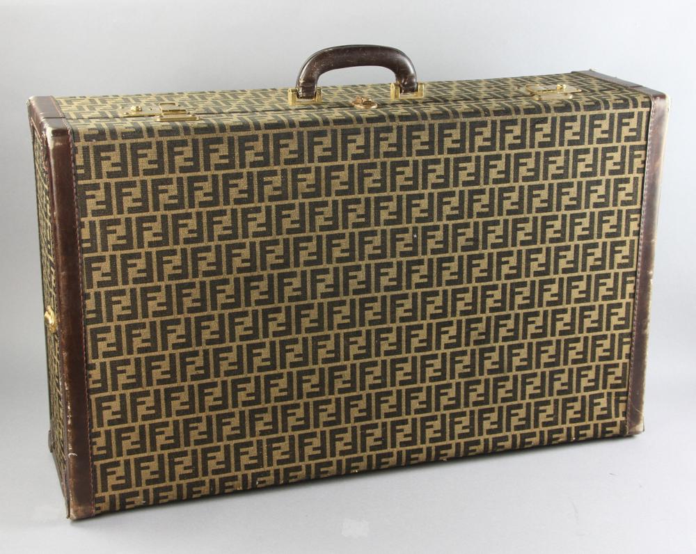 Fendi Logo Fabric and Leather Hardside Suitcase: Fendi logo fabric and leather hardside suitcase, 18" W x 30" L x 8 1/4" W. Provenance: From a Beverly, Massachusetts estate.