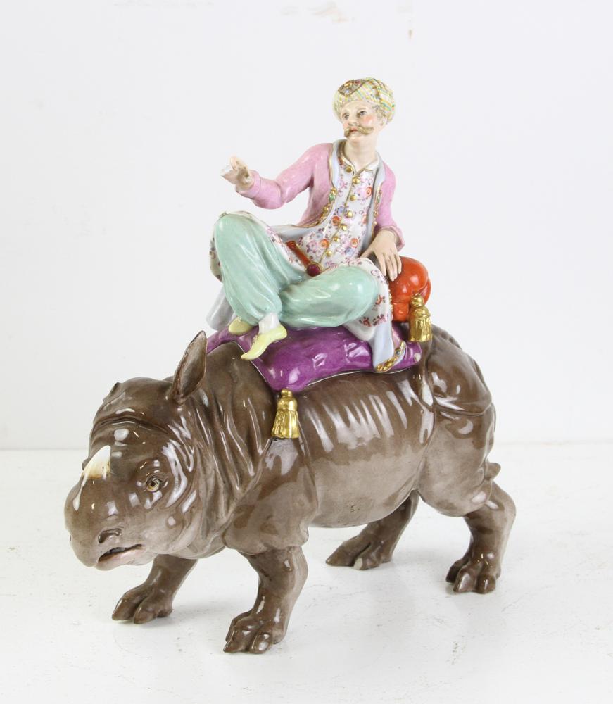 19thC German Meissen Porcelain Rhino: 19th century German Meissen pocelain rhino with sultan figure, chips and breaks throughout, cross sword mark on base, 10" H x 10" W.